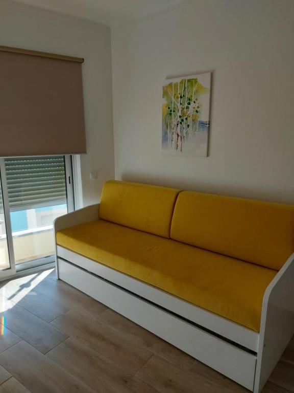 波尔蒂芒CASA BIA的窗户房间里一张黄色的沙发