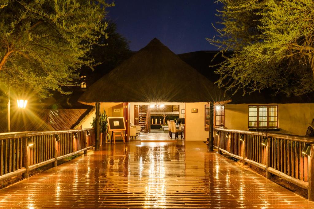 Rust de WinterMongena Private Game Lodge的夜晚,房子里的一个雨淋淋淋的走廊