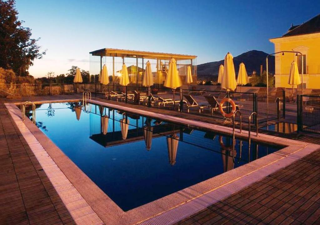 拉·格兰哈·圣·伊尔德拉格兰哈旅馆的游泳池旁设有椅子和遮阳伞