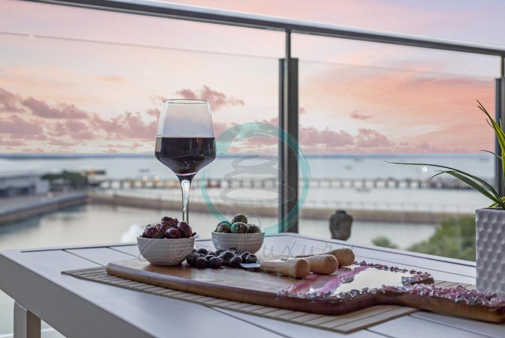 达尔文ZEN PENINSULA - Darwin's Prestigious WaterFront Retreat的一张桌子上的葡萄酒,享有大海美景