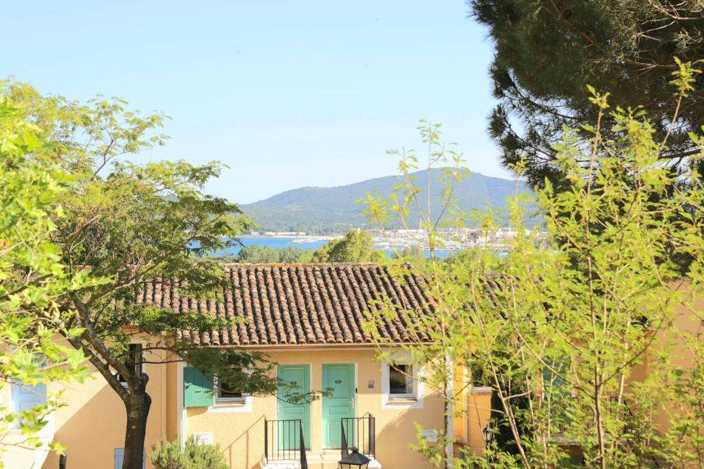 格里莫Chez Adriana Studio VUE MER avec Piscine的黄色的房子,有蓝色的门和树木