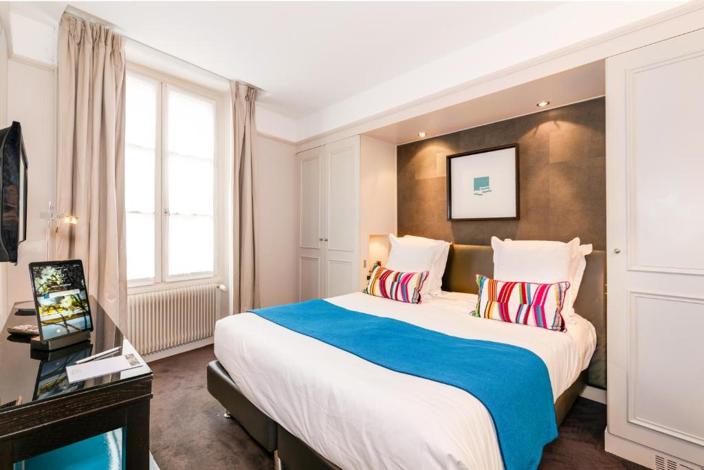 巴黎杜尔酒店的酒店客房设有一张大床和一台电视机。