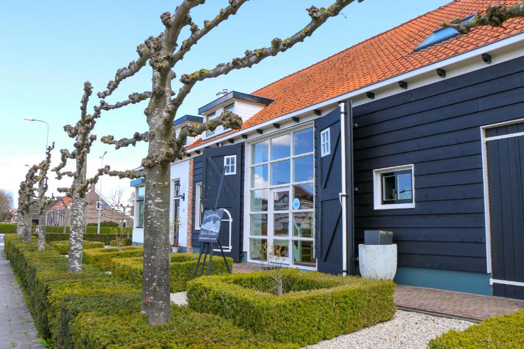 戈伊斯Oostmolenhoeve B&B的前面有树木的蓝色房子