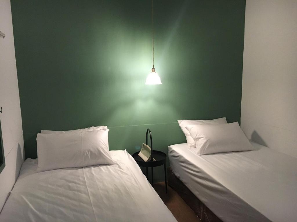 台南微光艺宿的绿墙客房的两张床