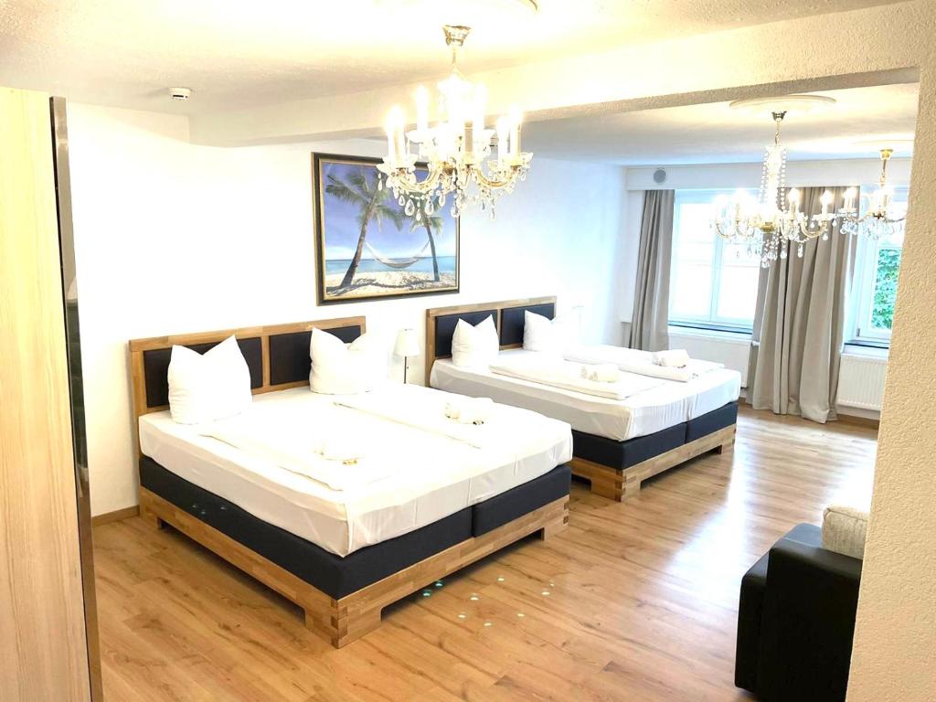 林道Hotel Garni Anker的一间卧室配有两张床和吊灯。