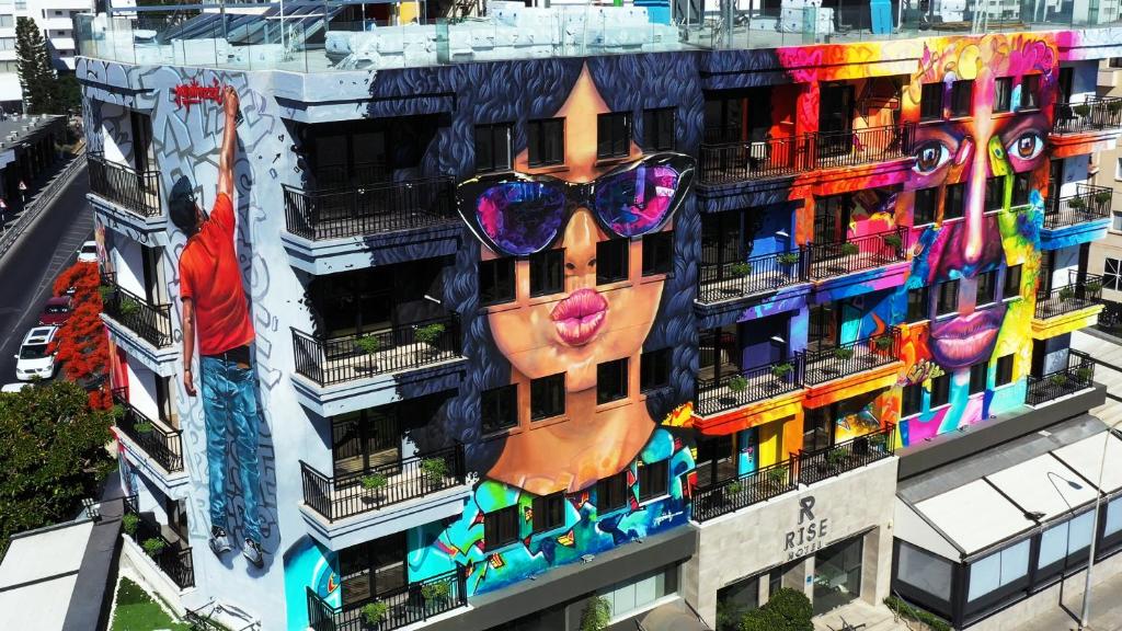 拉纳卡Rise Street Art Hotel的一座建筑,上面画着一张有太阳镜的脸