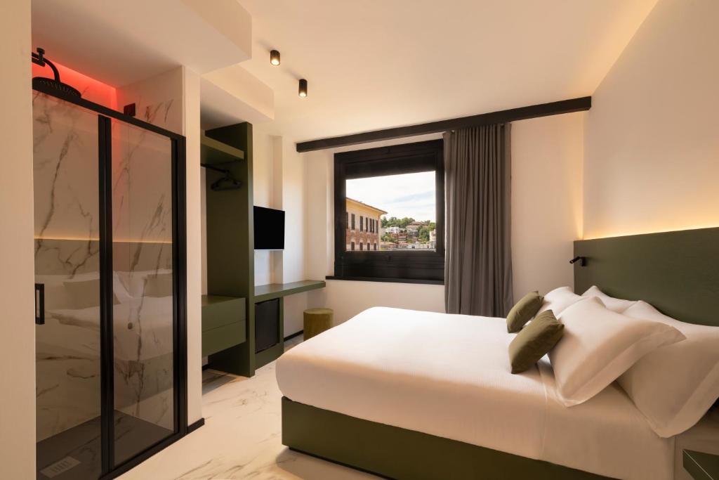 安科纳The City Hotel的卧室设有一张白色大床和一扇窗户。