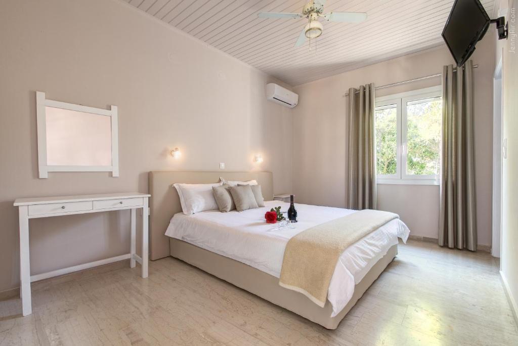 罗达天堂村公寓的卧室配有白色的床和窗户。