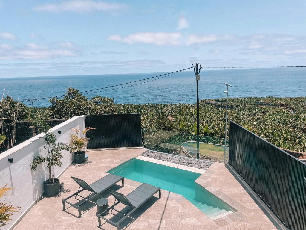 Las LedasLa Palma Luxury的一个带两把椅子的游泳池以及大海