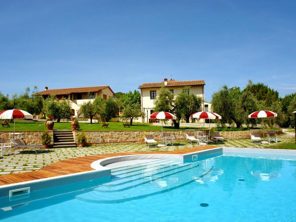 切雷托圭迪Holiday Home Borgo Fontana-7 by Interhome的一个带椅子和遮阳伞的游泳池以及一座房子