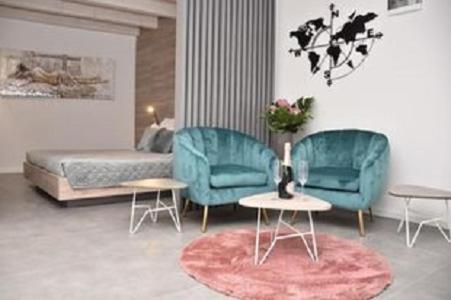 罗维尼Apartments Hidden paradise Rovinj的客厅配有2把蓝色椅子和1张床