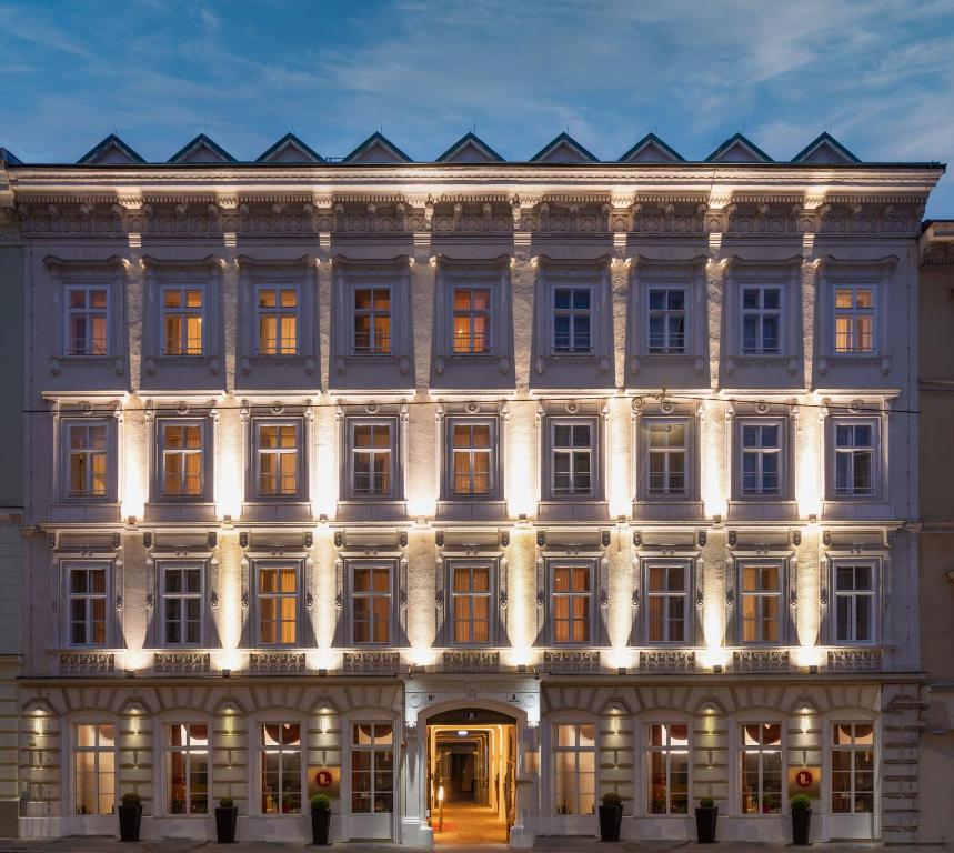 维也纳The Levante Rathaus Apartments的一座白色的大建筑,灯火通明