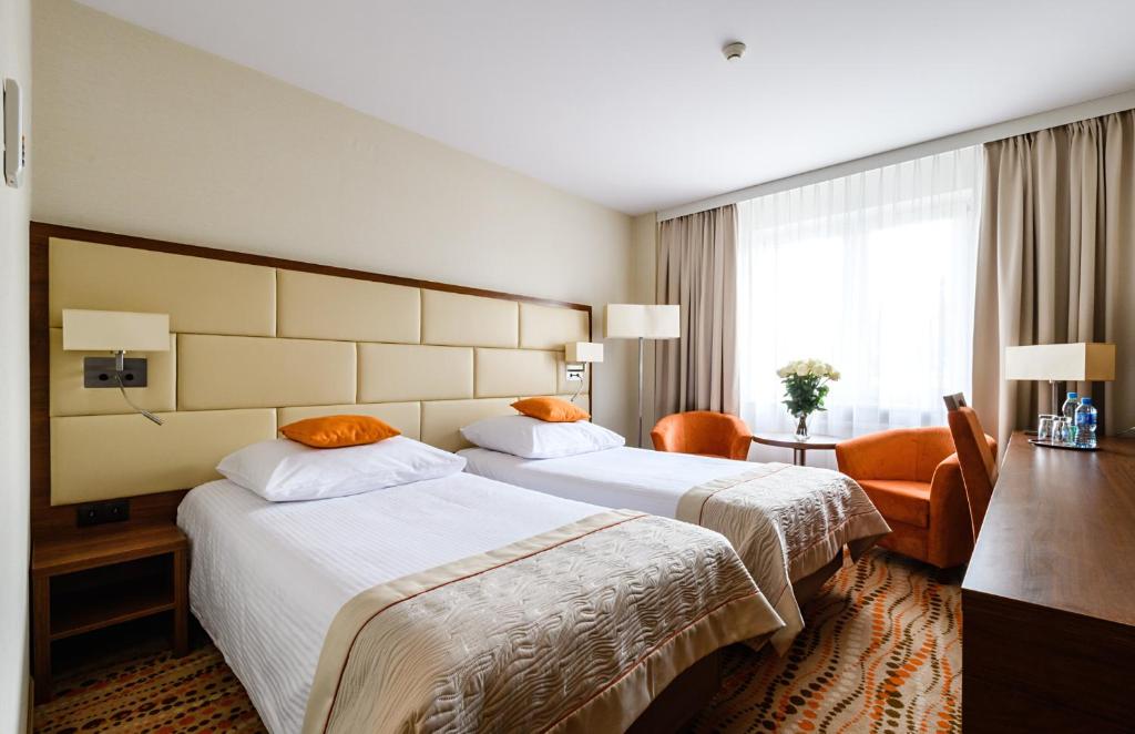 华沙波什酒店的酒店客房设有两张床和大窗户。
