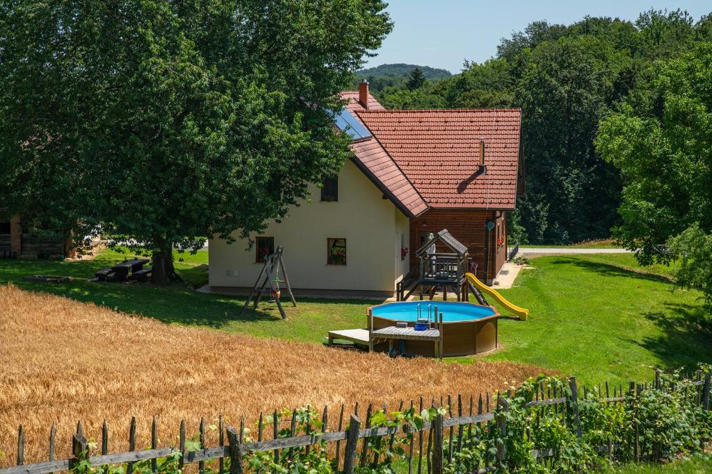Benedikt v Slovenskih GoricahTourist Farm Rajšp的庭院内带游乐场的小房子