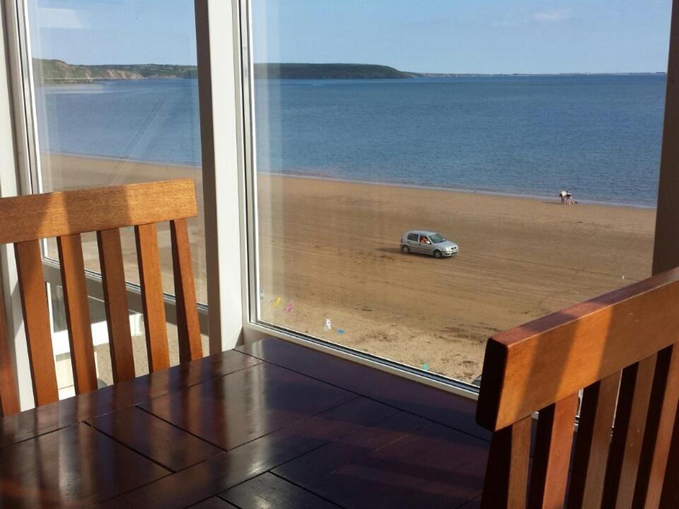 邓坎嫩赛丽斯住宿加早餐旅馆的一张享有海滩和汽车景致的桌子