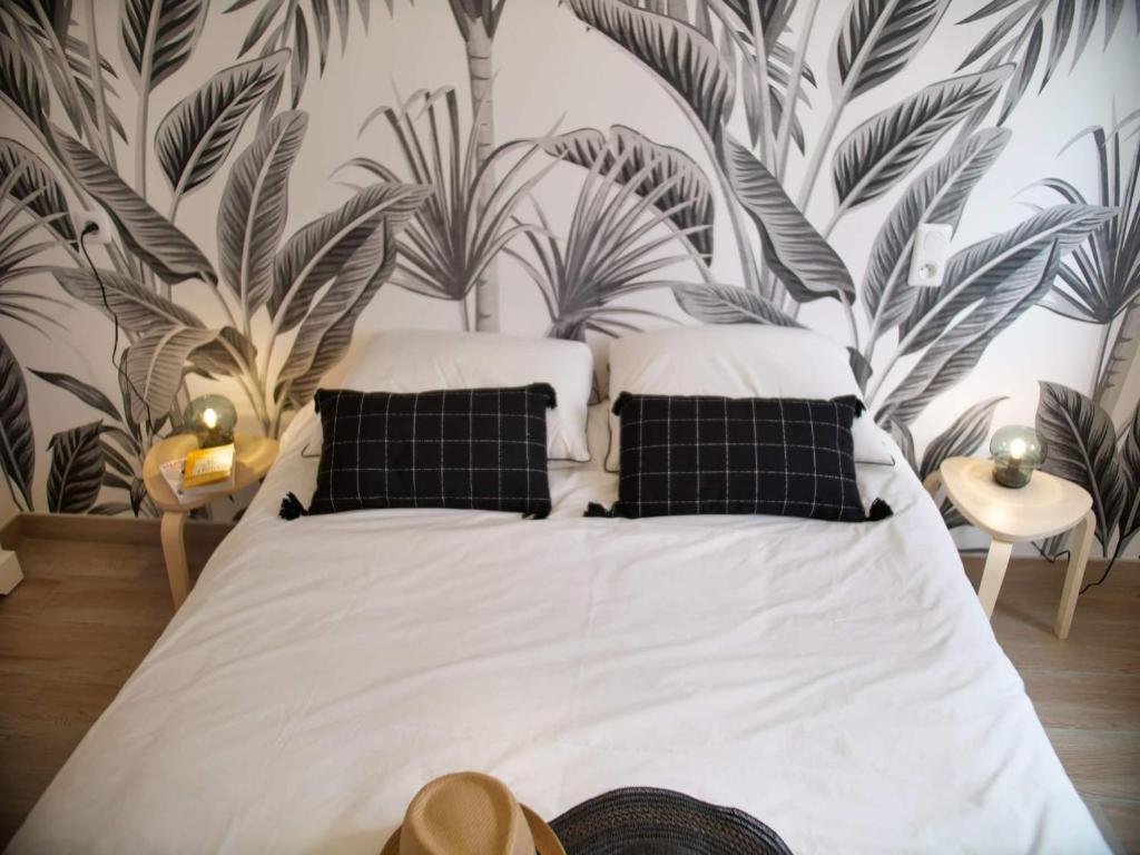 滨海克里耶勒Villa Emilie & Perrine的卧室配有一张挂在墙上的植物大床