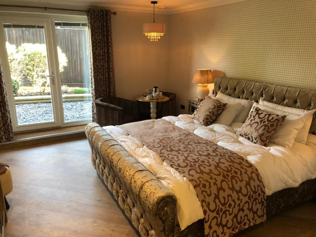 波尔顿乐法尔德Willow Lodge Hambleton的一间带一张大床的卧室,位于带窗户的房间内