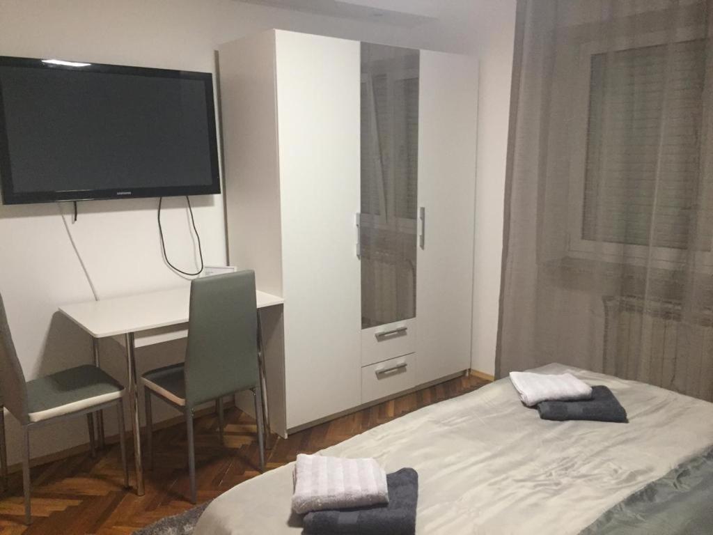 奥西耶克Apartmani Anton的客房设有床、书桌和电视。
