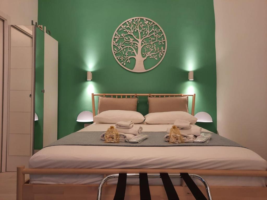 那不勒斯GELSO HOME的一间绿色卧室,配有一张床铺,上面有两只猫