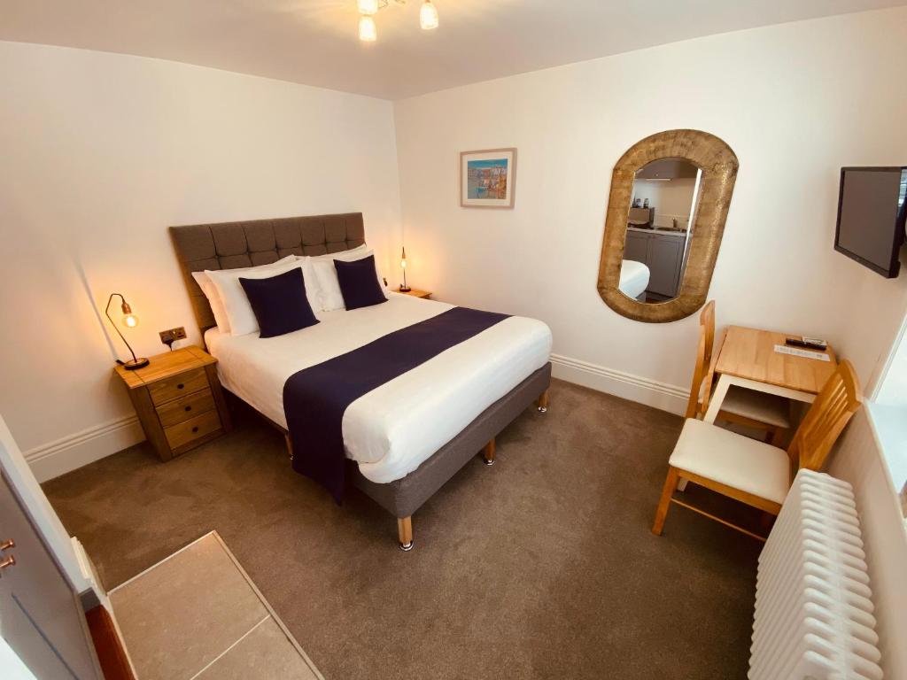 韦茅斯Self Contained Guest Suite 1 - Weymouth的一间卧室配有一张大床和镜子