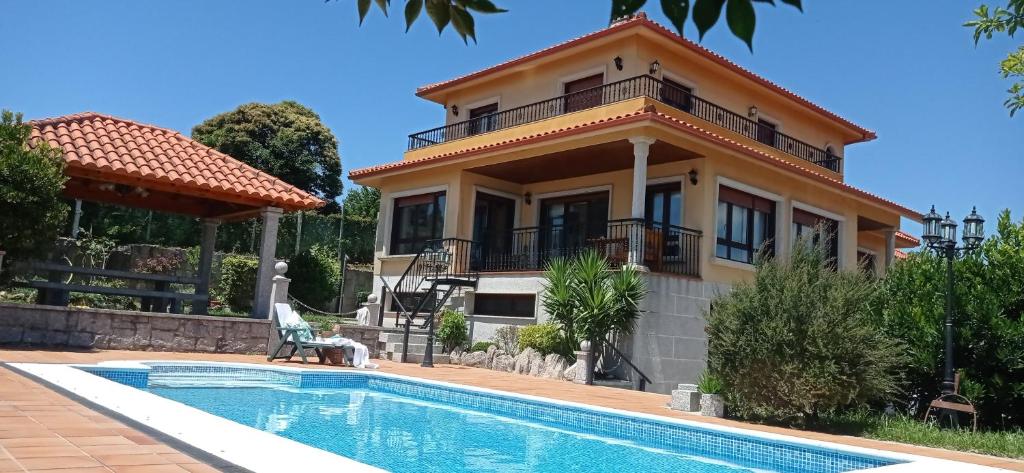 莫阿尼亚Itxi y Jamin - Chalet con vistas a la Ria de Vigo的一座带游泳池和房子的别墅