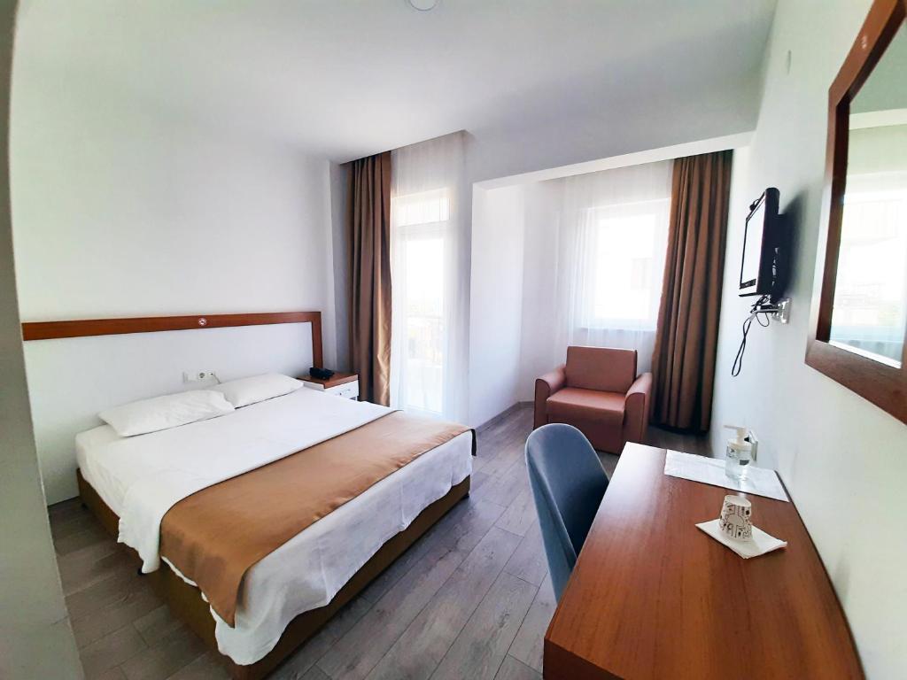 安塔利亚Karden Otel的酒店客房配有一张床铺和一张桌子。