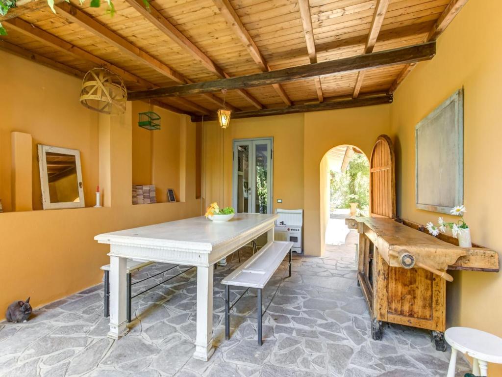 比萨Belvilla by OYO Villa Lazzarino的一间设有白色桌子和木制天花板的用餐室