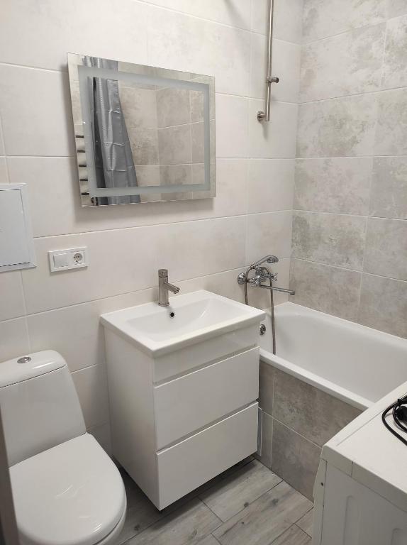 罗夫诺2 комнатная с новым ремонтом, кондиционером, в самом центре的浴室配有盥洗盆、卫生间和浴缸。