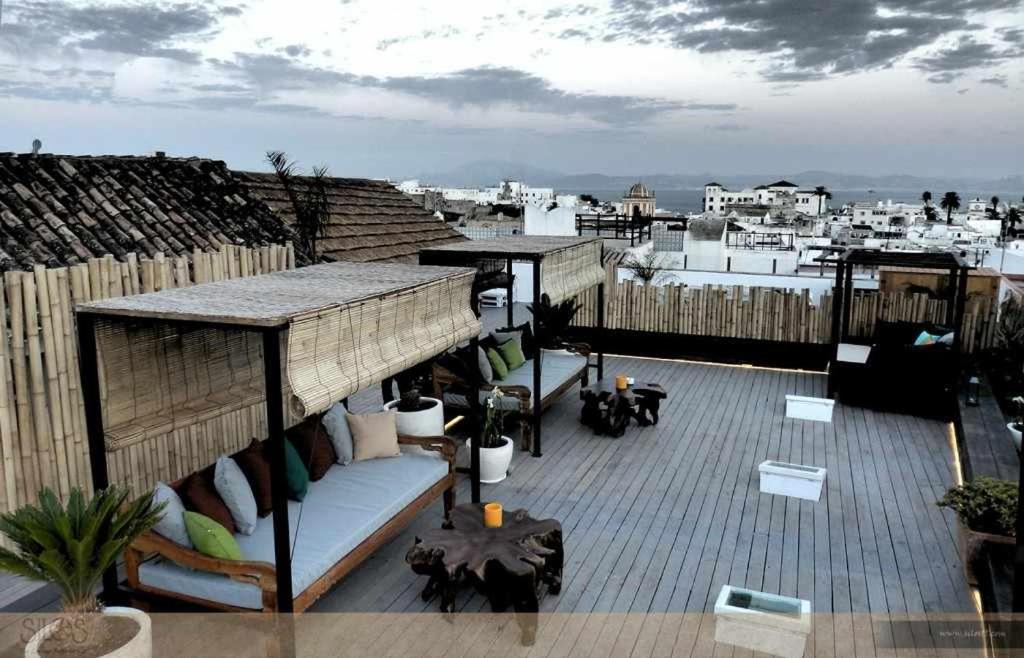 塔里法斯罗斯19号套房旅馆的屋顶上设有一个带沙发和桌子的屋顶露台