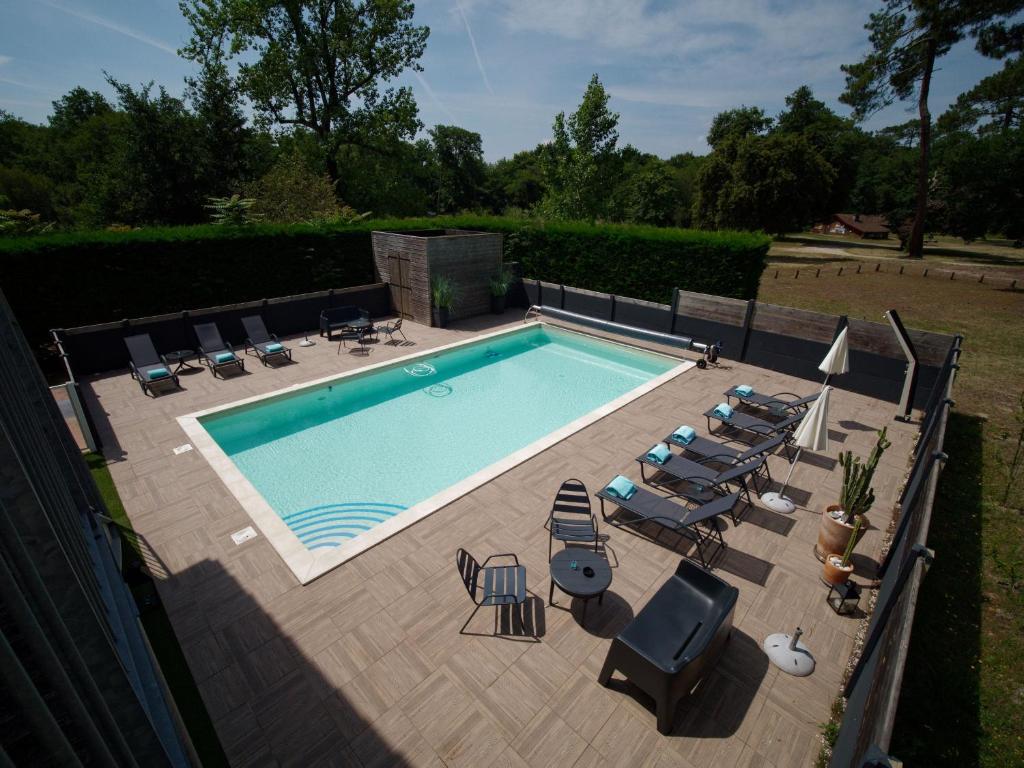米米藏Hotel Au Bon Coin du Lac的享有带躺椅的游泳池的顶部景致