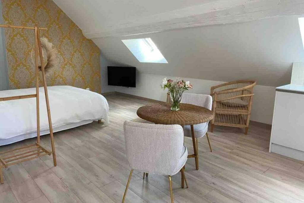 博讷Au coin des Hospices的一间卧室配有一张床和一张鲜花桌子