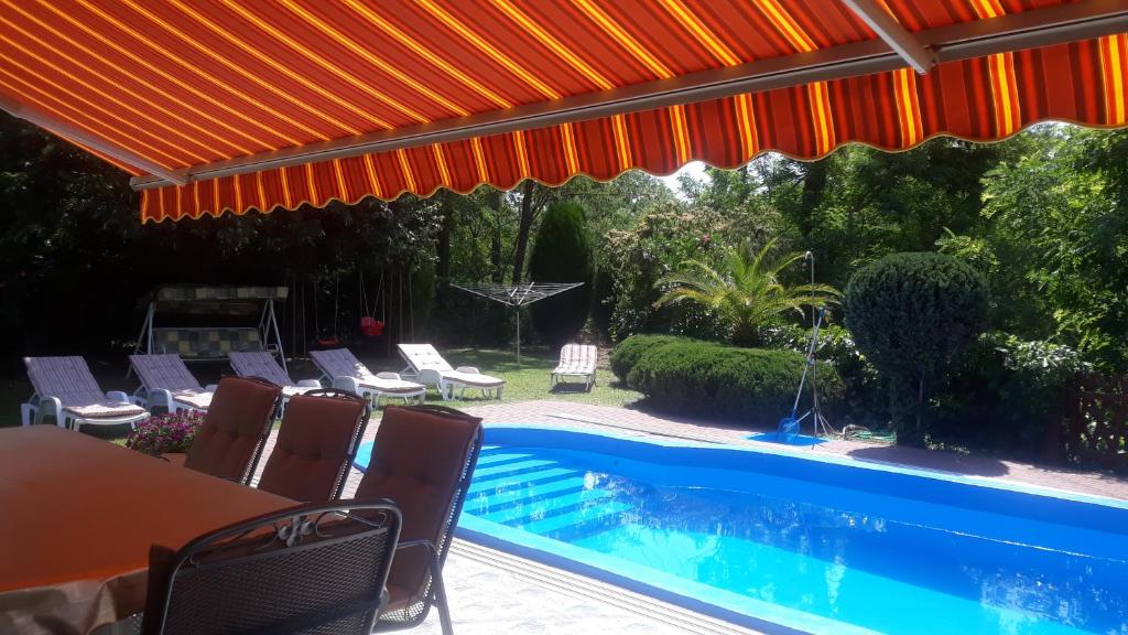 福纽德Király Nyaraló的一个带桌椅的庭院和一个游泳池