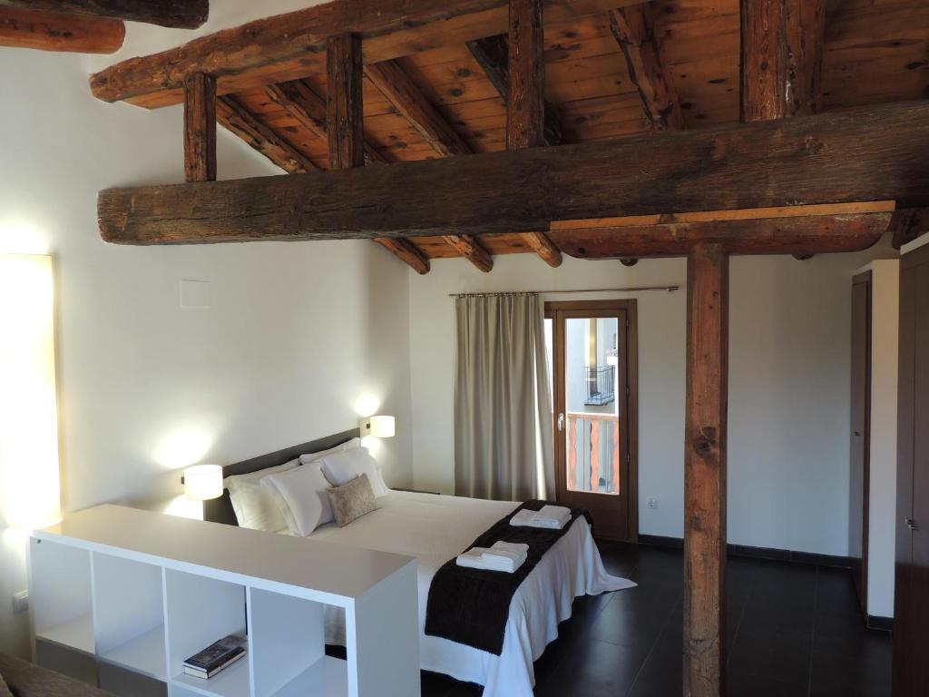 莫雷拉Casa Rural Vistes de Morella的卧室设有白色的床和木制天花板。