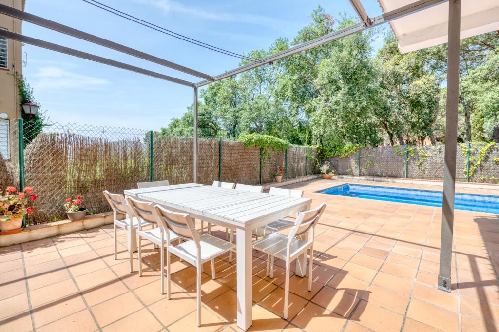 卡莱利亚德帕拉弗鲁赫尔Villa Sierra with Private Pool的一个带白色桌椅的庭院和一个游泳池