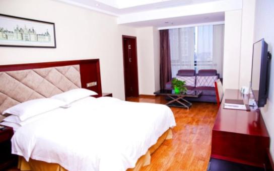 成都格林豪泰四川省成都市机场路珠江路快捷酒店的卧室配有一张白色大床和一张书桌