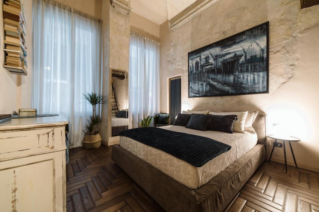 热那亚Nil Sine Deo的卧室配有一张床,墙上挂有绘画作品