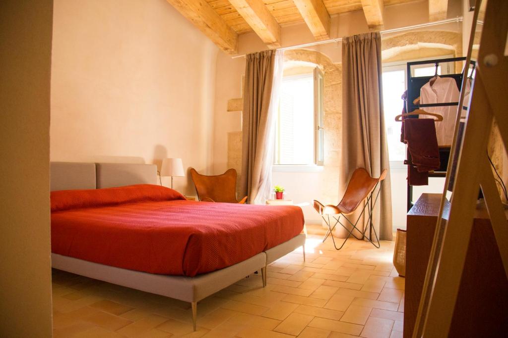 萨萨里Locanda Carra Manna的一间卧室设有红色的床和窗户。