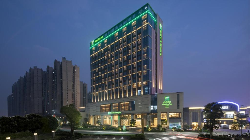 Shunde顺德保利假日酒店的一座高大的建筑,上面有绿灯
