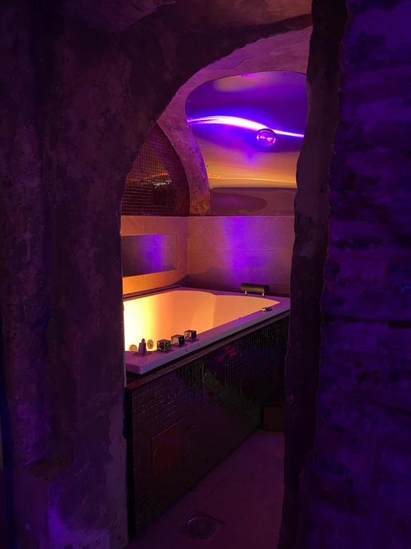 里尔Private Room & Spa avec jacuzzi privatif的一间带紫色照明浴缸的浴室