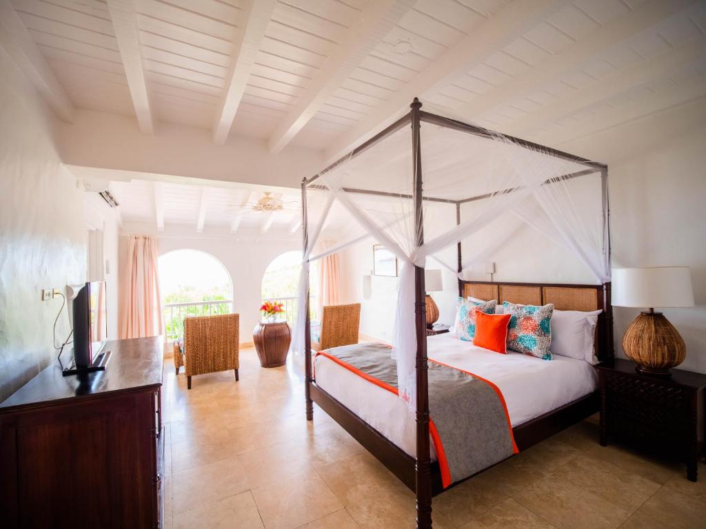 格罗斯岛温德亚马尔登陆海滩别墅度假村的一间卧室配有一张天蓬床和一台电视机