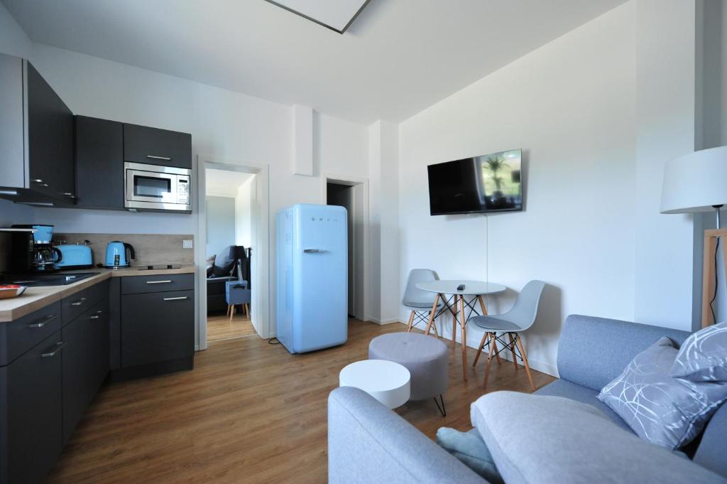 维利希Appartm. Schwarzen Pfuhl的厨房以及带蓝色冰箱的起居室。