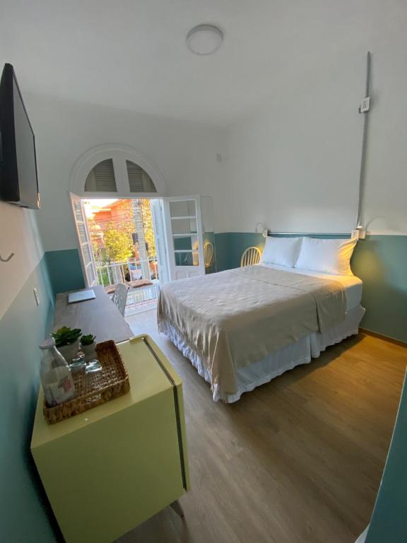圣保罗Angatu Hostel的一间卧室配有一张大床和一张桌子及四柱床