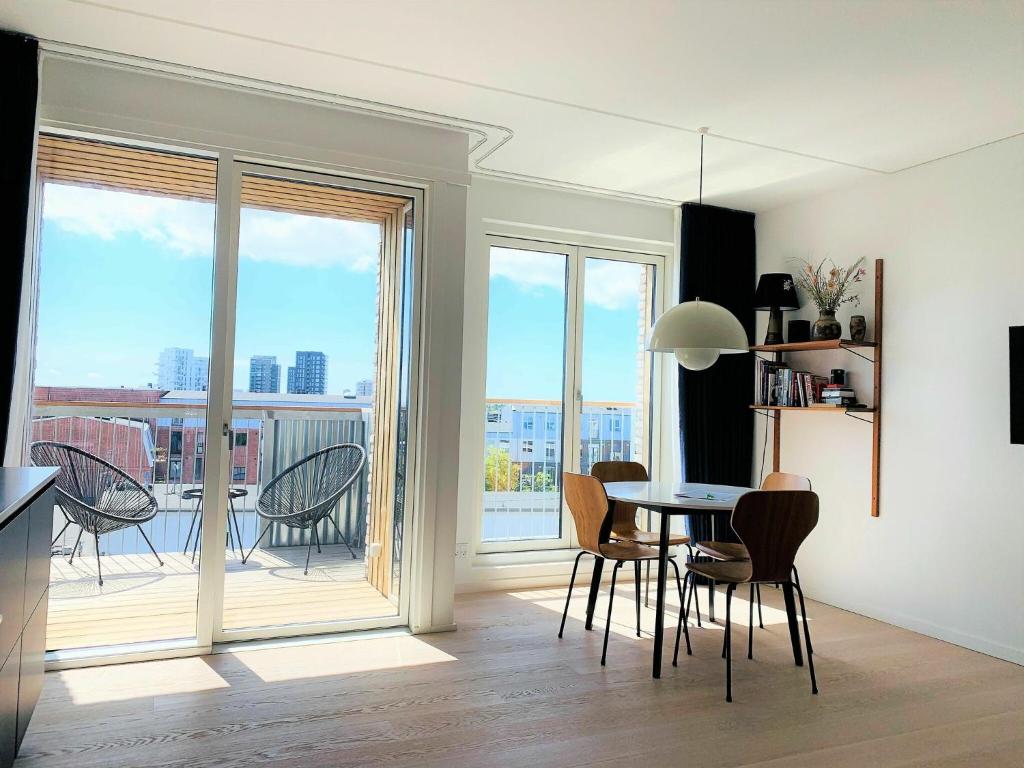 哥本哈根ApartmentInCopenhagen Apartment 1453的一间带桌椅的客厅和一个阳台