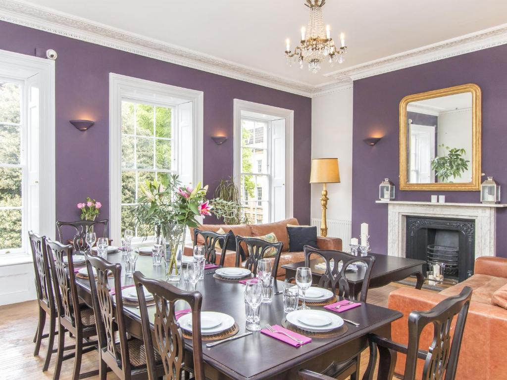 布里斯托3 Berkeley Square Guesthouse的一间拥有紫色墙壁和桌椅的用餐室