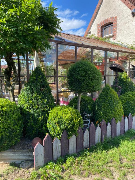 Thiel-sur-AcolinLa Maison du Bonheur的一座带围栏的房屋前的花园