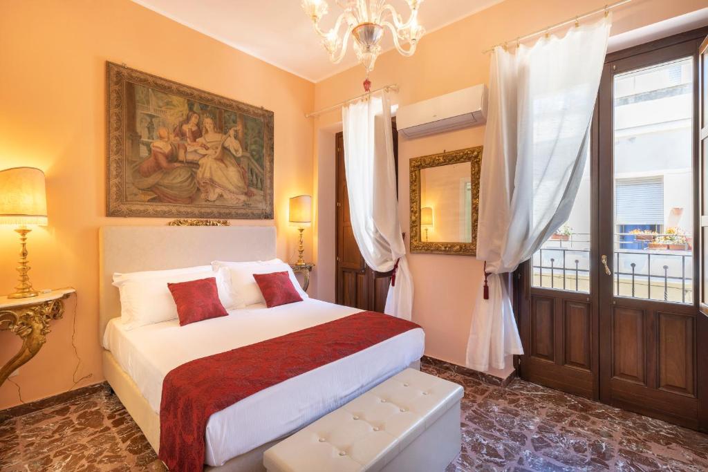 帕基诺Saint George's House Appartamenti & Spa的一间卧室设有一张床、一个窗户和一个吊灯。
