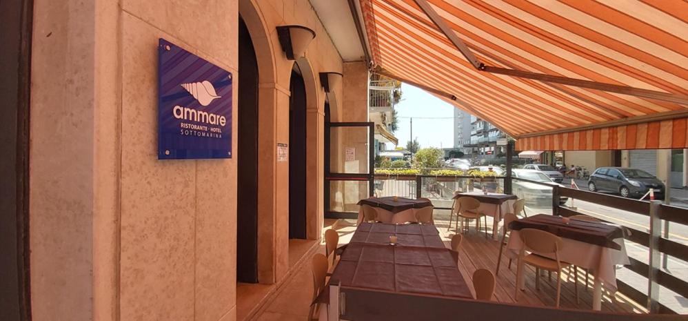 索托马里纳Hotel Ammare的阳台餐厅,配有桌椅