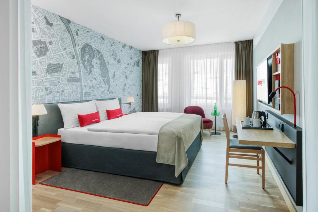 格拉茨IntercityHotel Graz的配有一张床和一张书桌的酒店客房