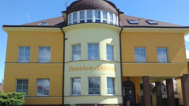 奥赫热河畔克拉什泰莱茨Pension ASTORIA的上面有冒险剂标志的黄白色建筑