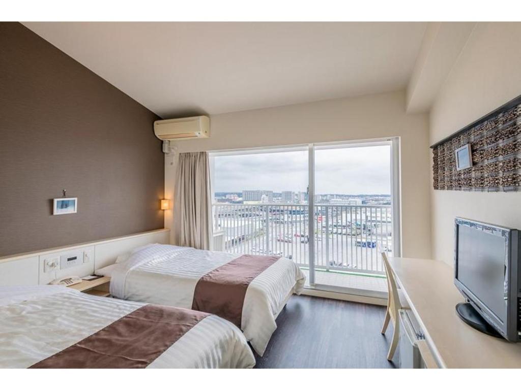 丰见城市HOTEL GranView Garden OKINAWA - Vacation STAY 44961v的酒店客房设有两张床和大窗户。